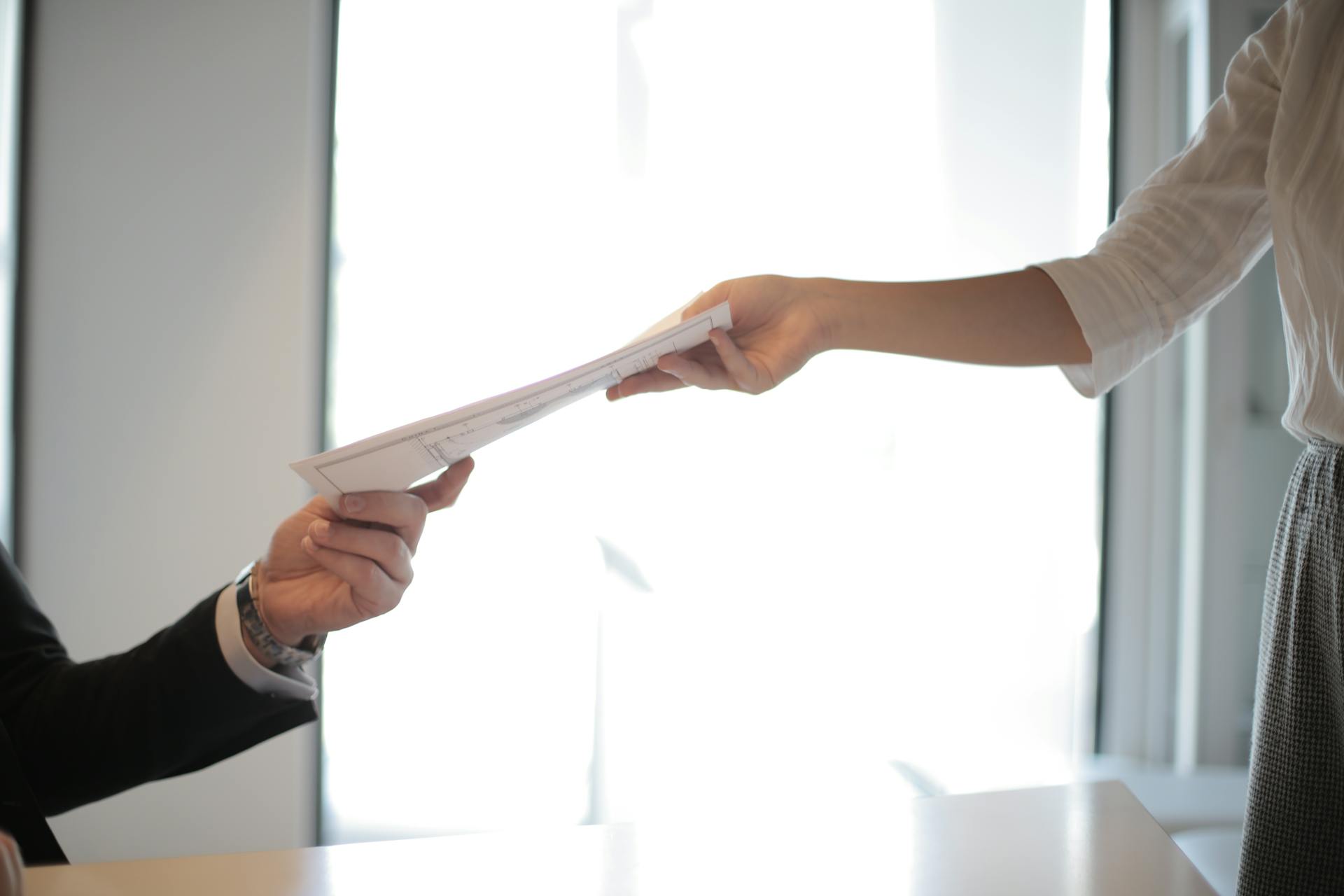 Image of man handing off papers to a woman, symbolizing succession