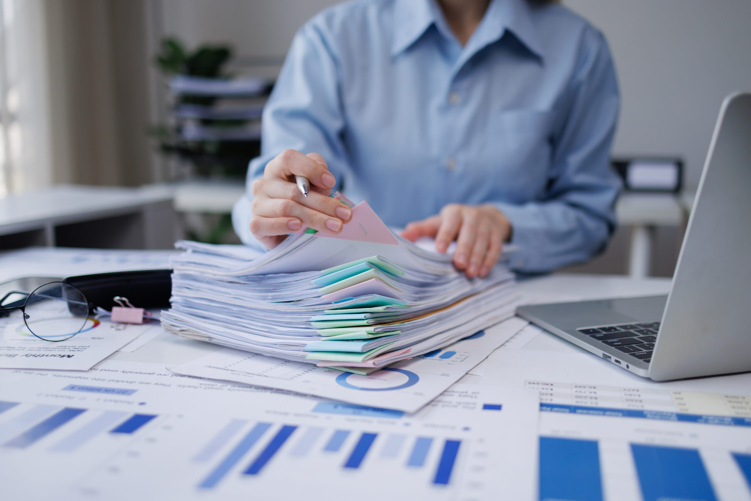 Organized workspace representing administrative family office services — labeled binders, financial reports, and consolidated wealth records